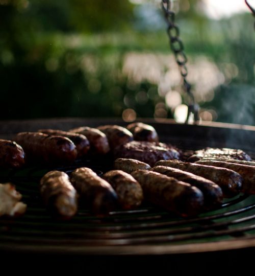 BBQ over the firepit in our lakeside shepherd's huts